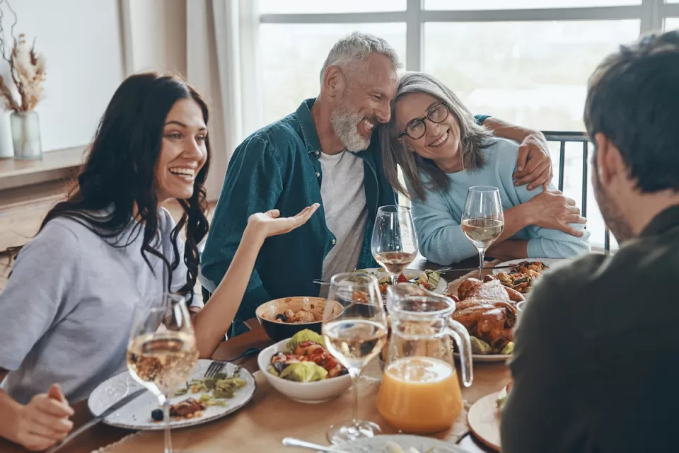 Multi-generational white family sits around dining table